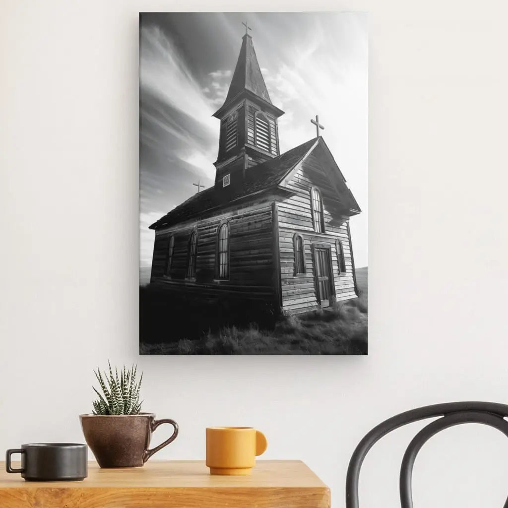 Le Tableau Eglise en Bois Noir et Blanc est exposé sur un mur au dessus d'une table en bois ornée d'une petite plante et de deux coupes, créant une décoration apaisante.