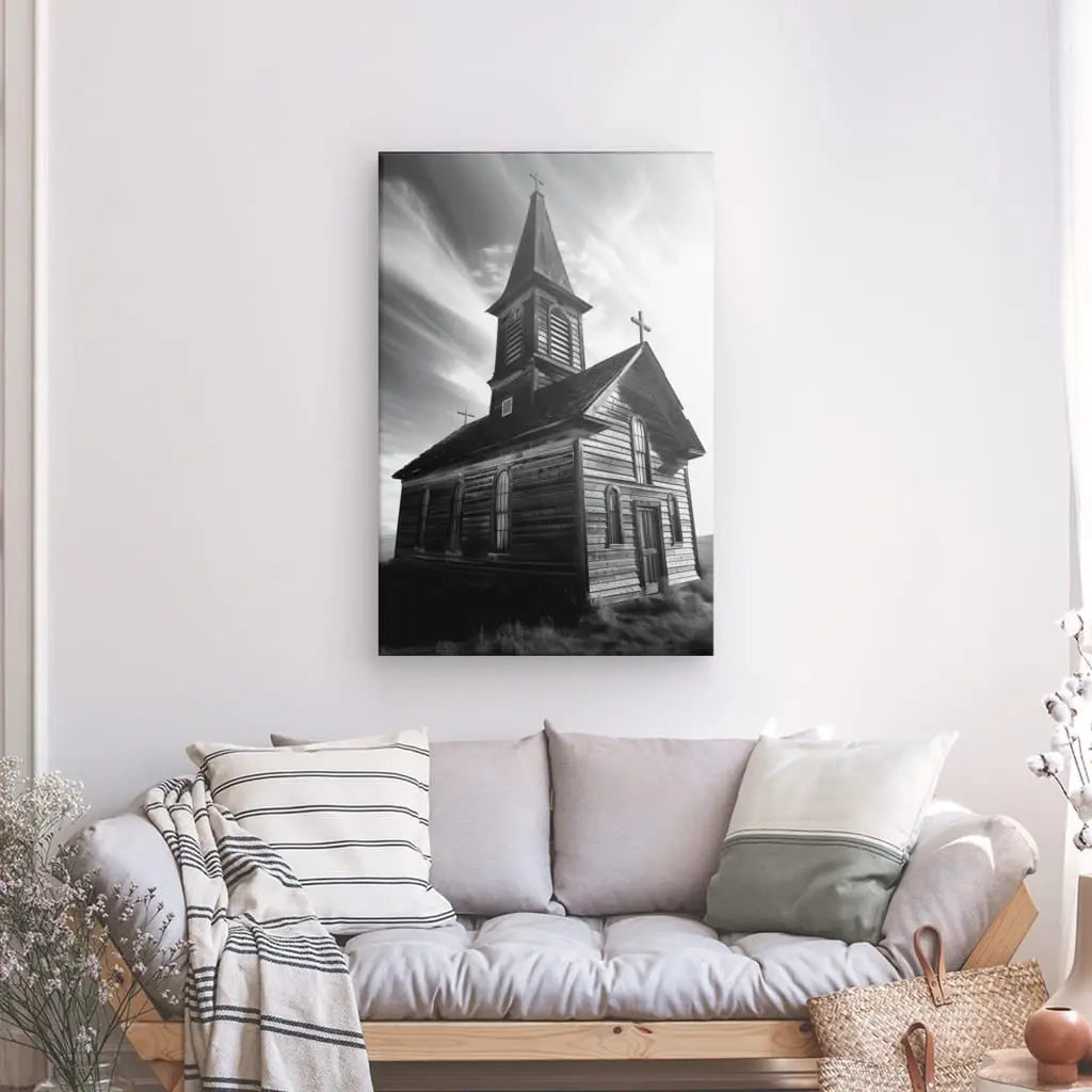 Un Tableau Eglise en Bois Noir et Blanc est accroché sur un mur blanc au-dessus d'un canapé clair orné de coussins rayés et unis. Des objets décoratifs ajoutent à la décoration apaisante sur le côté.