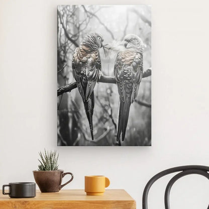 Le Tableau Perruches Inséparables Branche Monochrome Rosé, une reproduction photographique sur toile tendue à la main représentant deux oiseaux perchés sur une branche dans une scène de nature monochrome aux nuances rosées, est accroché au-dessus d'une table en bois ornée d'une petite plante en pot et de trois tasses, créant un cadre serein.