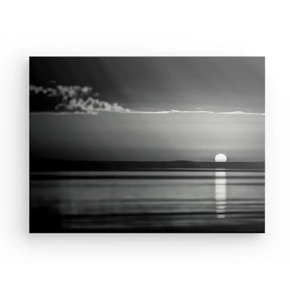 Le Tableau Coucher de Soleil Mer Noir et Blanc, magistralement reproduit à l'aide d'encres HP Latex, capture le soleil se couchant sur un plan d'eau calme avec une fine ligne de nuages près de l'horizon.