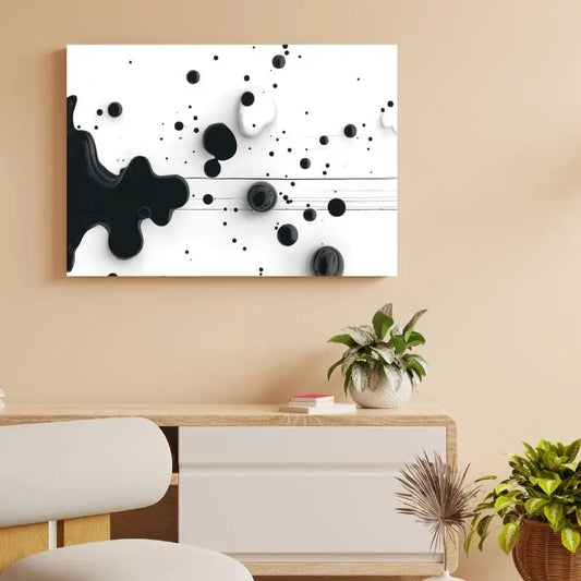 Tableau représentant des gouttes de peinture noire sur fond blanc, œuvre minimaliste et graphique pour décoration murale moderne
