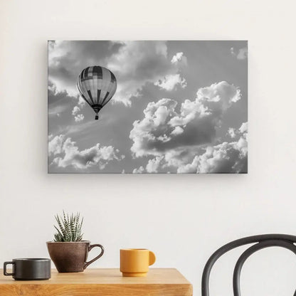 Tableau noir et blanc d’une montgolfière dans le ciel au-dessus d’un paysage, scène aérienne poétique et légère
