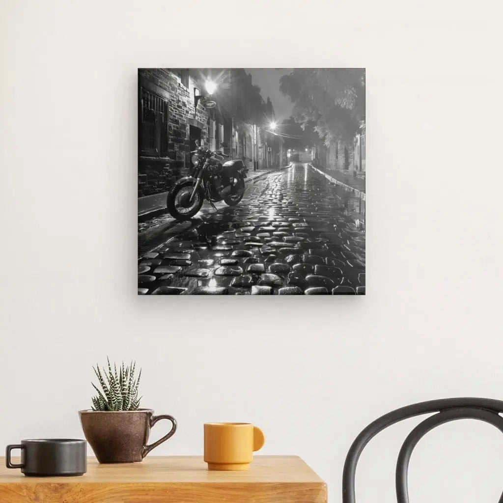 Tableau en noir et blanc d’une moto dans une rue pavée et pluvieuse, scène urbaine et atmosphérique pour décoration murale
