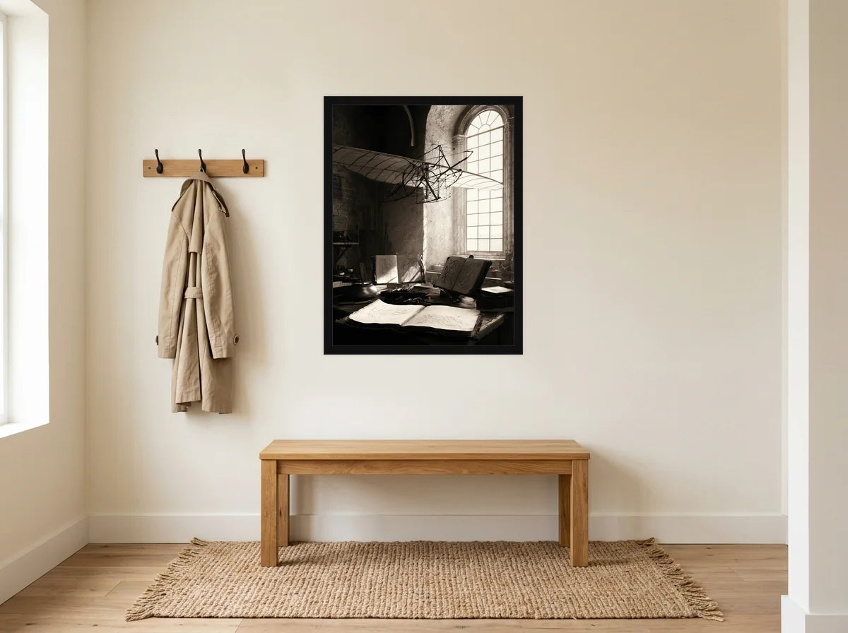 Poster atelier de léonard noir et blanc encadré noir, mis en scène dans : entrée crème avec banc en bois