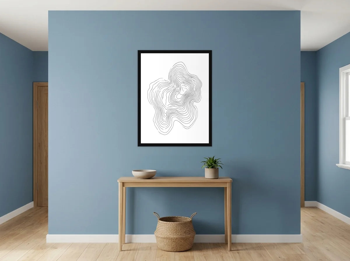Poster courbes topographiques organiques noir et blanc encadré noir, présenté dans un intérieur lumineux