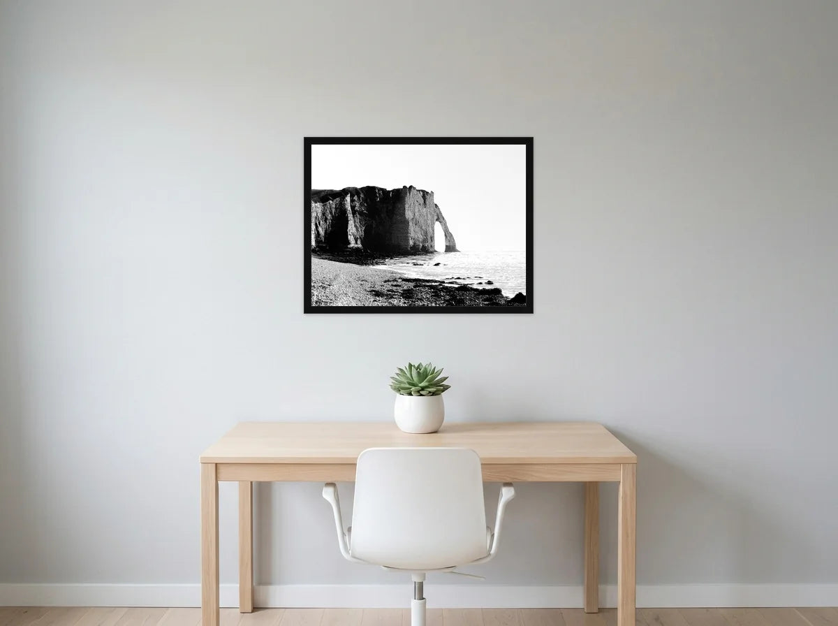 Poster falaises d’étretat noir et blanc encadré noir, présenté dans bureau gris clair lumineux