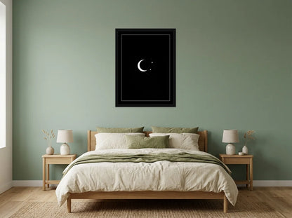 Poster lune et étoiles noir et blanc encadré noir, présenté dans une chambre aux murs vert sauge
