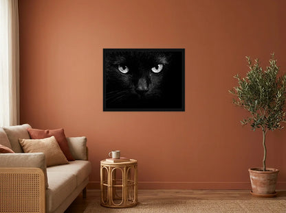 Poster portrait de chat noir encadré noir, présenté dans un salon aux murs terracotta