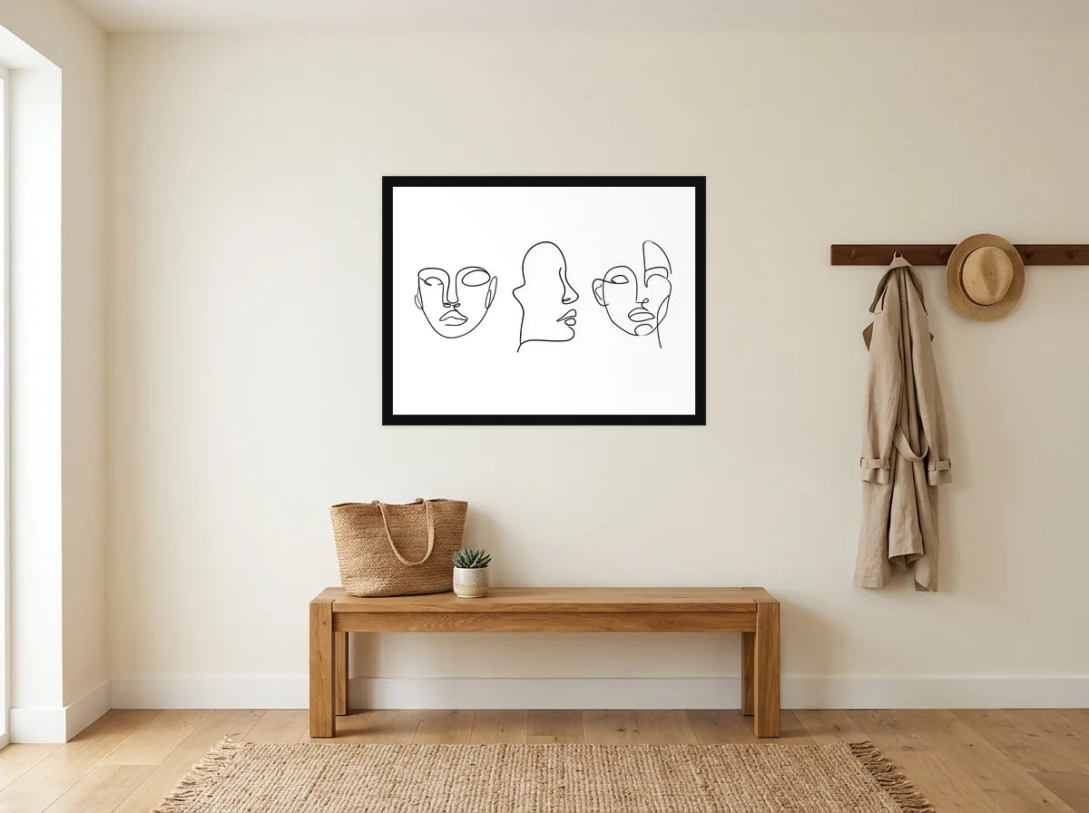 Poster Trois Visages au Trait noir et blanc encadré noir, présenté dans une entrée crème avec banc en bois