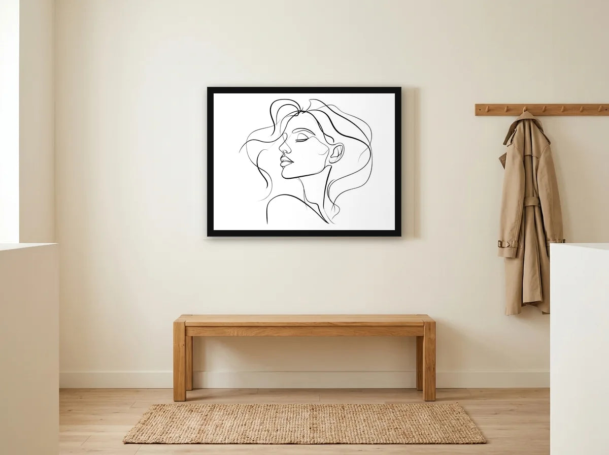 Poster visage féminin au trait noir et blanc encadré noir, présenté dans un intérieur lumineux