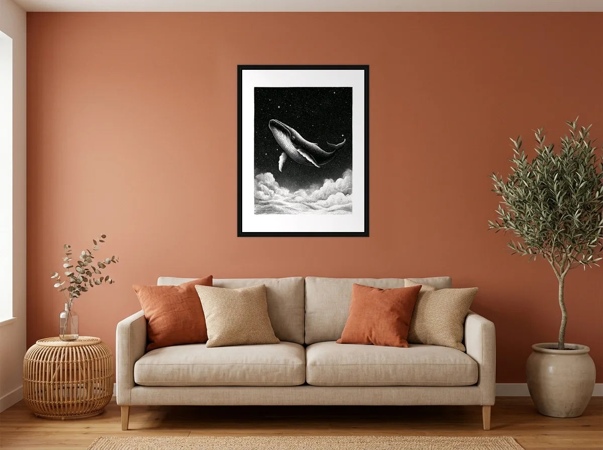 Tableau baleine au-dessus des nuages noir et blanc en toile encadrée noire, présenté dans : salon aux murs terracotta