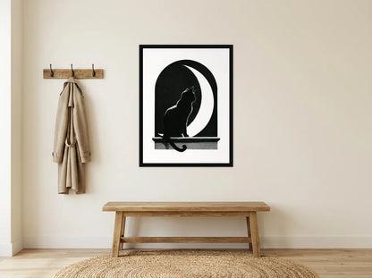 Tableau chat noir sous la lune en toile encadrée noire, présenté dans une entrée crème avec banc en bois