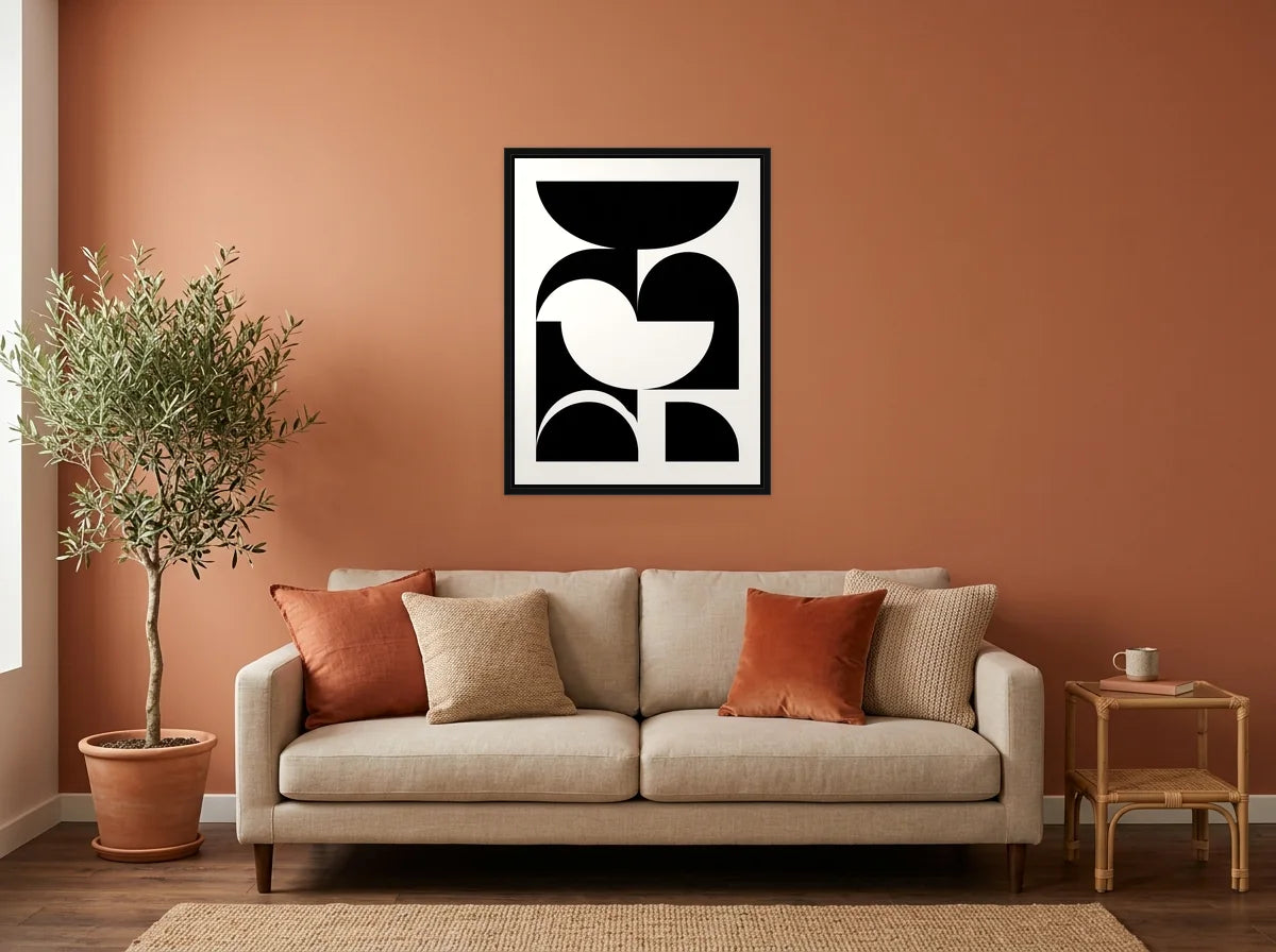 Tableau composition Bauhaus géométrique noir et blanc en toile encadrée noire, présenté dans un salon aux murs terracotta