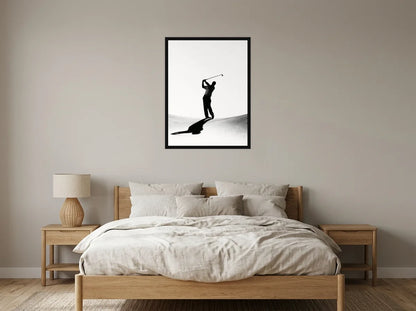 Tableau golfeur en fin de swing noir et blanc en toile encadrée noire, présenté dans : chambre aux tons lin et grège