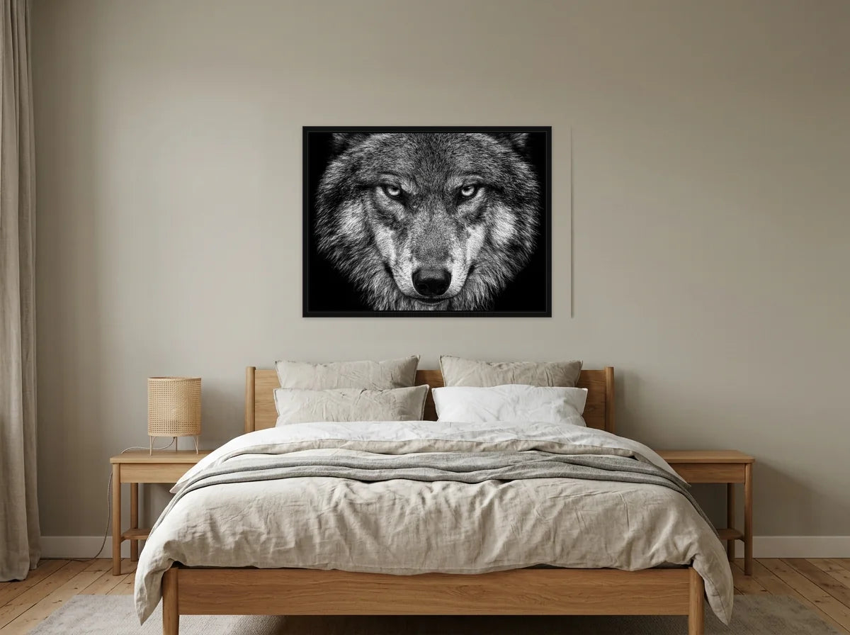 Tableau loup au regard perçant noir et blanc en toile encadrée noire, présenté dans : chambre aux tons lin et grège