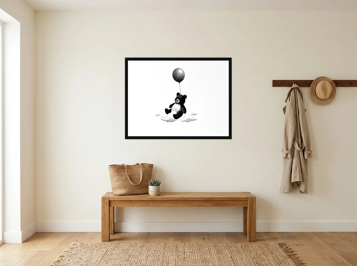 Tableau ourson au ballon noir et blanc en toile encadrée noire, présenté dans : entrée crème avec banc en bois