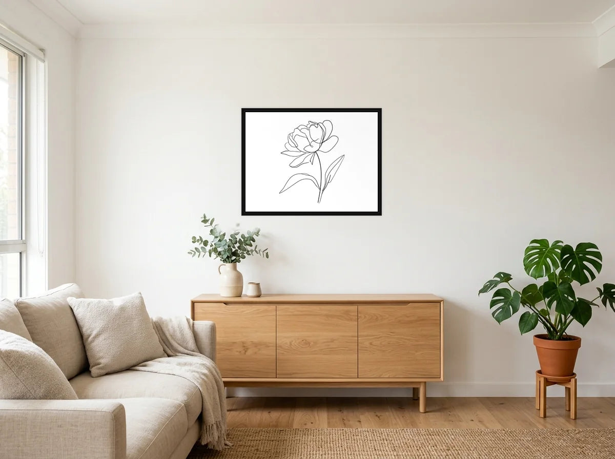 Tableau Pivoine au Trait noir et blanc en toile encadrée noire, présenté dans un salon blanc chaleureux et bois clair