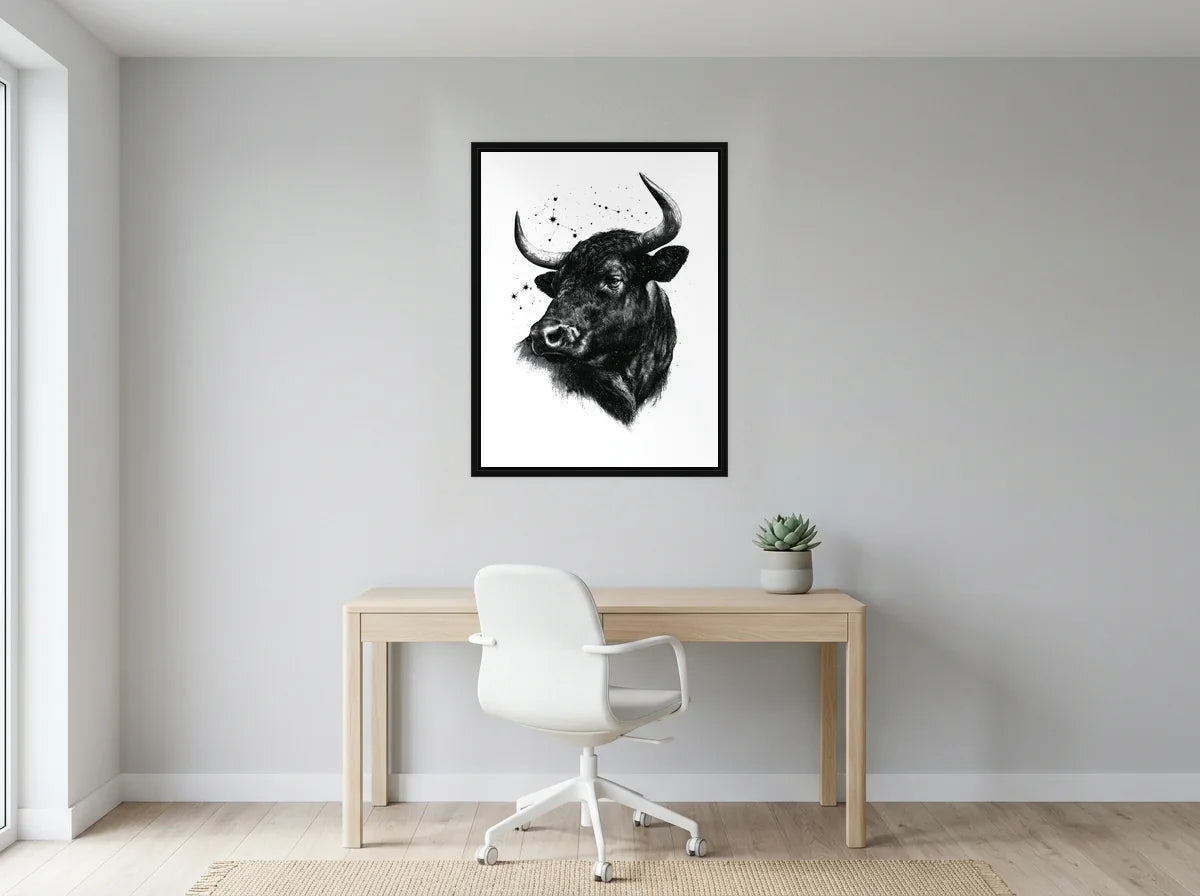 Tableau taureau sous les étoiles noir et blanc en toile encadrée noire, présenté dans : bureau gris clair lumineux