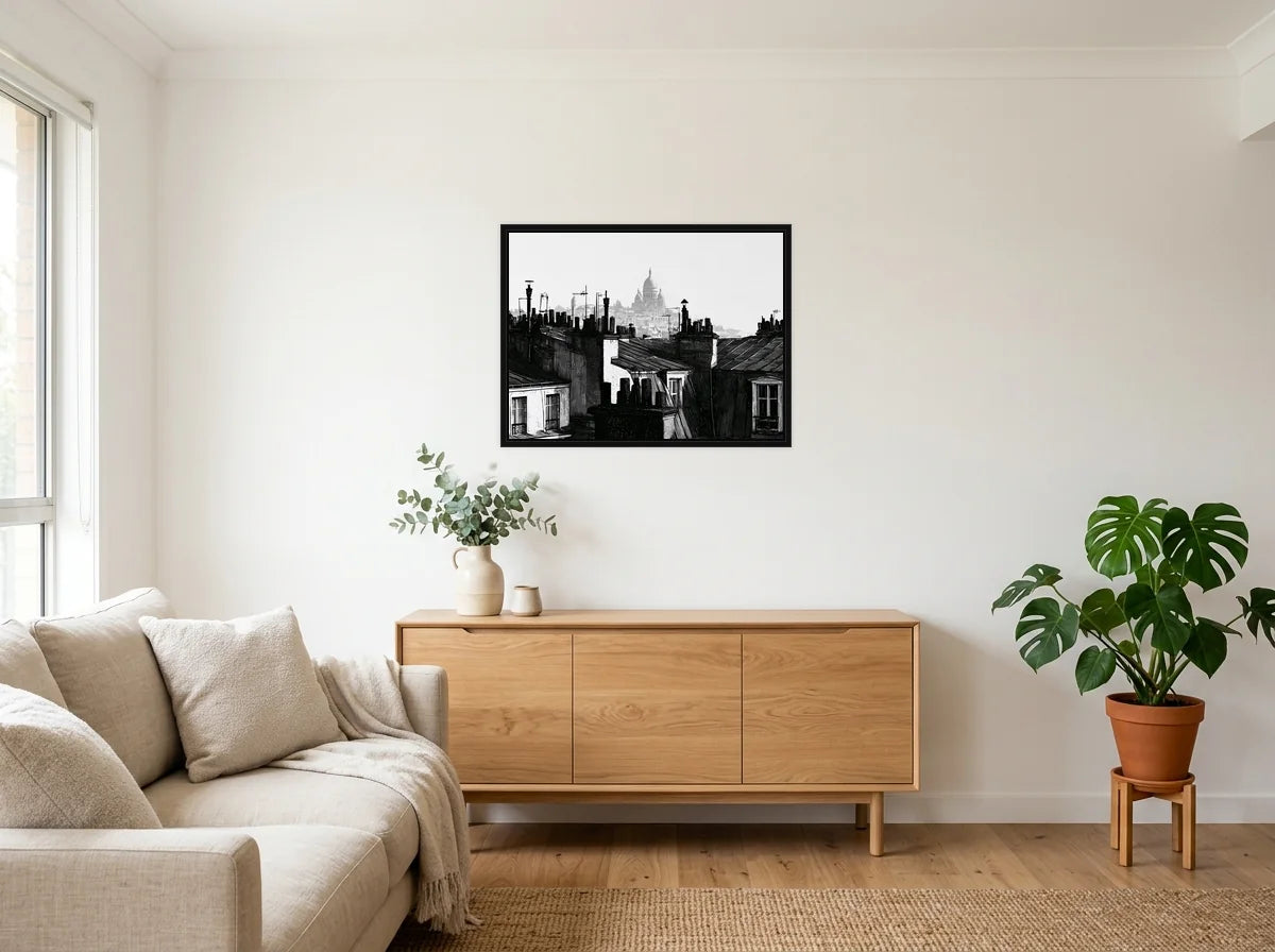 Tableau toits de montmartre noir et blanc en toile encadrée noire, présenté dans un salon blanc chaleureux et bois clair