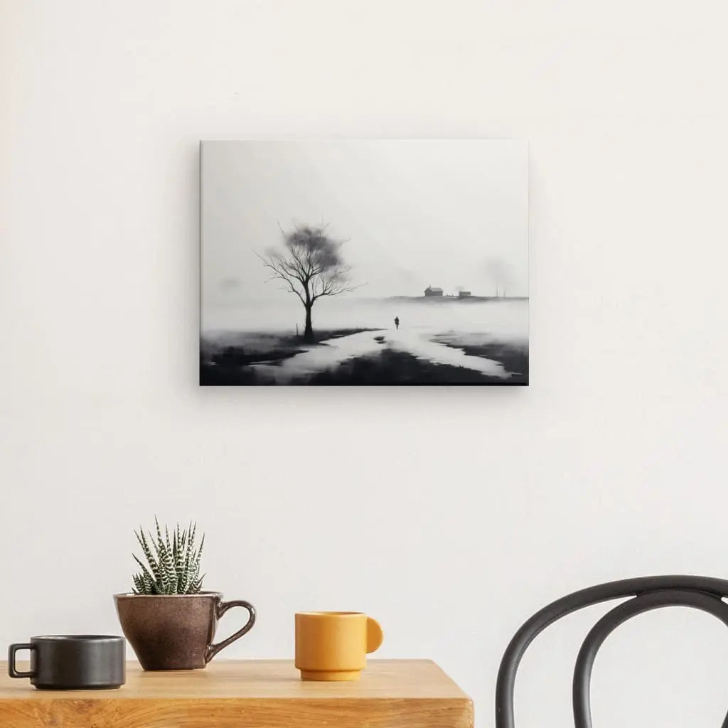 Un Tableau Peinture Campagne Champ Paysage Noir et Blanc représentant un arbre orne le mur, avec un dessus de table présentant un petit cactus en pot et trois tasses. Une chaise noire se trouve sur le côté droit de cette scène sereine.