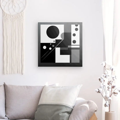 Une œuvre d'art géométrique en noir et blanc, un élégant Tableau Formes Géométriques Noir et Blanc Art Abstrait Décoration Minimaliste Cercles, est accrochée à un mur blanc au-dessus d'un canapé beige avec des coussins gris. Un cotonnier se trouve sur le côté droit, et une tenture murale en macramé incarne la déco intérieure minimaliste à gauche.