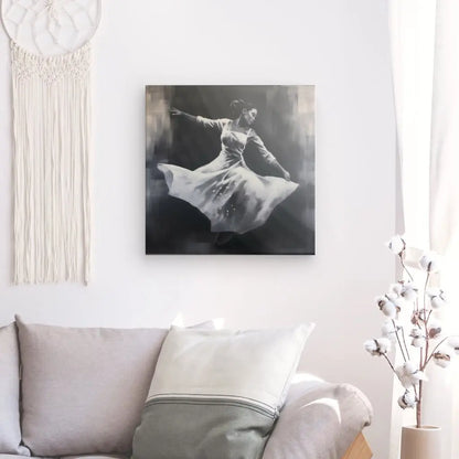 Un Tableau Danseuse Noir et Blanc Peinture Monochrome représentant une personne dansante est accroché sur un mur blanc au-dessus d'un canapé. Une tenture murale en macramé et un vase avec des tiges de coton sont également exposés, créant un décor élégant qui met en valeur la beauté de l'art de la danse.