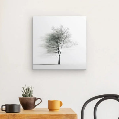 Un Tableau Arbre Minimaliste Nature Originale Noir et Blanc est accroché sur un mur blanc au-dessus d'une table en bois contenant deux tasses et une petite plante en pot.