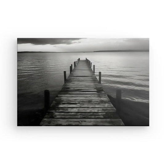 Une reproduction de tableau d'une photographie en noir et blanc d'une jetée en bois s'étendant dans un plan d'eau calme sous un ciel nuageux, imprimée sur toile tendue avec des encres latex HP.