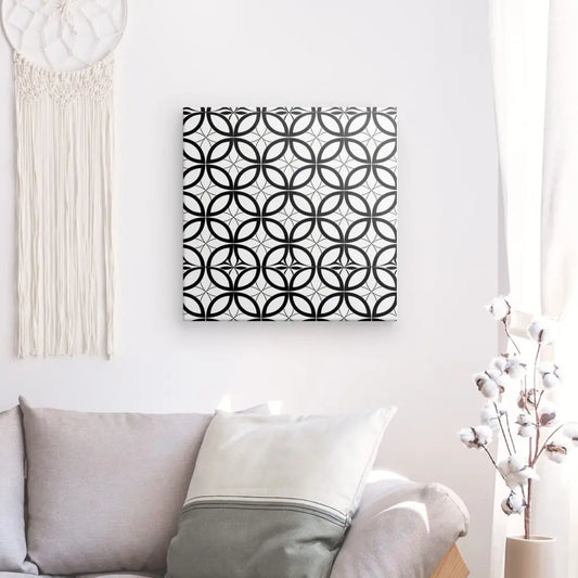 Un mur de salon moderne décoré d'une toile Tableau Motifs Géométriques Mosaïque Noir et Blanc, imprimée avec des encres latex HP pour une définition d'impression améliorée, et d'une tenture murale en macramé.