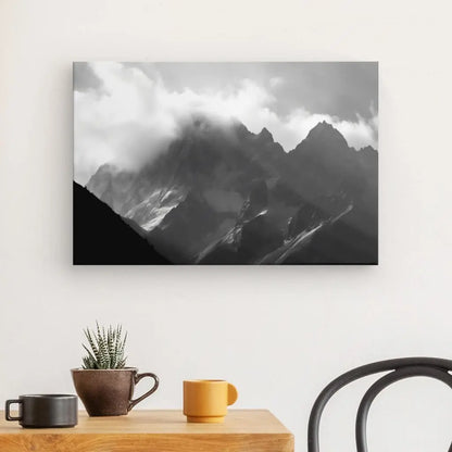 Reproduction photo du Tableau Montagnes Rocheuses Paysage Alpes Noir et Blanc affichée au-dessus d'un bureau moderne avec une plante en pot et deux tasses, imprimée sur toile à l'aide d'encres latex HP.