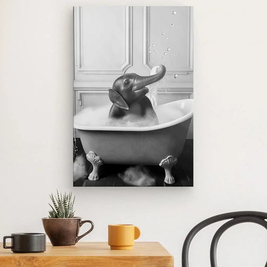 Un tableau fantaisiste Elephant Salle de Bain Baignoire Portrait Animaux Noir et Blanc montrant un éléphant pulvérisant joyeusement de l'eau assis dans une baignoire, créé avec des encres latex HP, accroché au-dessus d'une table d'appoint moderne avec une plante et deux m
